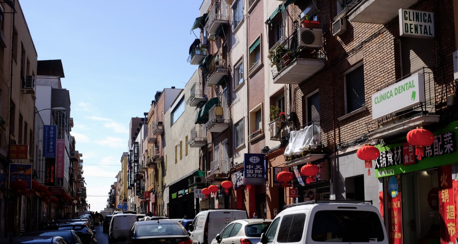 Calle de Usera con farolillos rojos colgados sobre las tiendas y rótulos en chino y en español