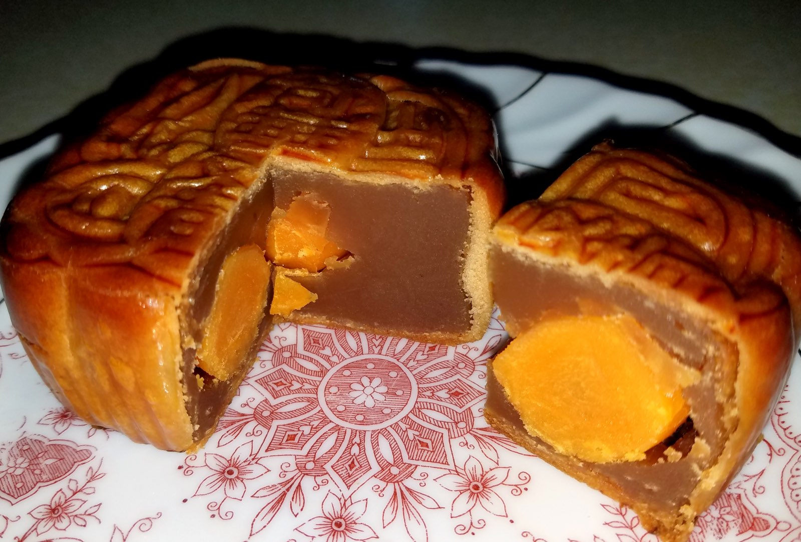 Pastel de luna cantonés partido en dos, con la yema de huevo salada en el centro de la pasta